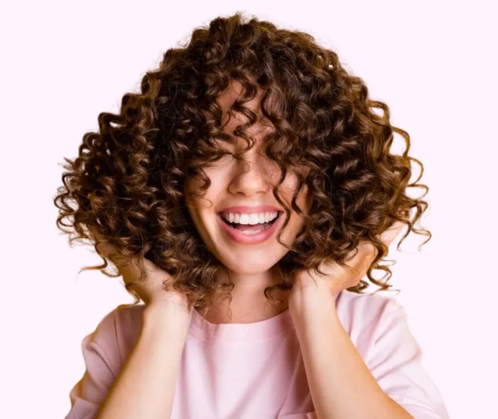 Woman proudly holds and displays her beautifully defined bouncy curl by curl
